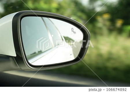 Rear view mirror, close-up, with reflection of a white car when the car is moving. An essential element for driving safety. 106674892