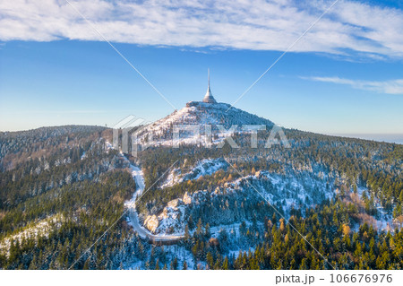 Jested mountain with modern hotel and TV transmitter on the top, Liberec, Czech Republic. Sunny winter day with snowy landscape. Aerial view from drone. Jested mountain with modern hotel and TV transmitter on the top, Liberec, Czech Republic. Sunny winter day with snowy landscape. Aerial view from drone. 106676976