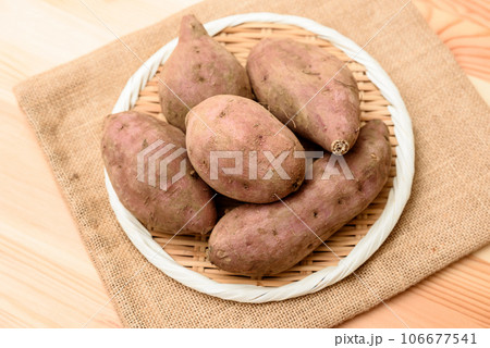 明るめテーブル上の麻袋の上のザルに盛られた安納芋　サツマイモ 106677541