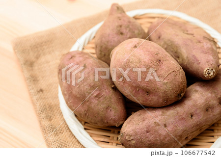 明るめテーブル上の麻袋の上のザルに盛られた安納芋　サツマイモ 106677542