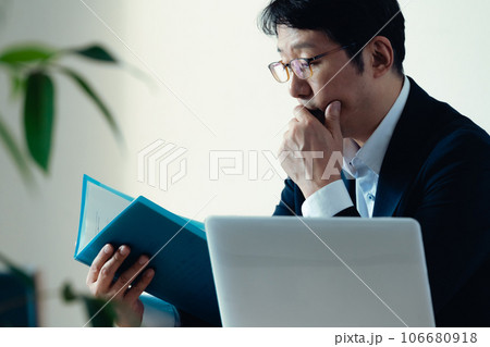 書類を見て悩むビジネスマン 106680918