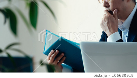 書類を見て悩むビジネスマン 106680919