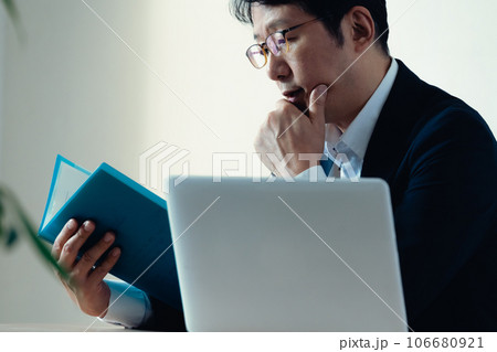 書類を見て悩むビジネスマン 106680921