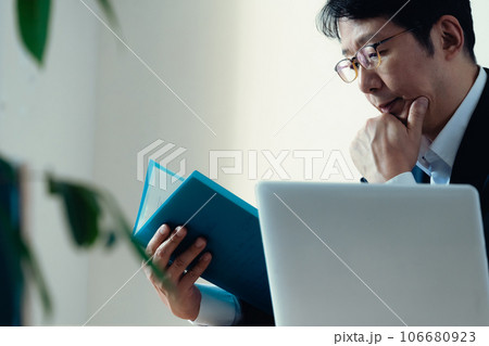 書類を見て悩むビジネスマン 106680923