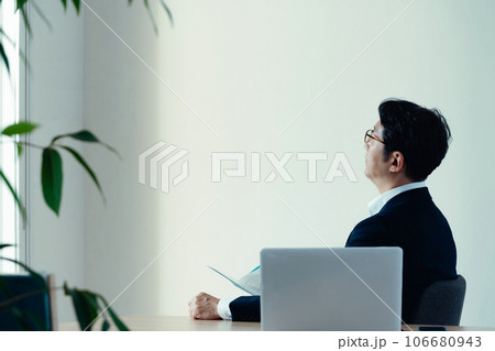 書類を見て悩むビジネスマン 106680943