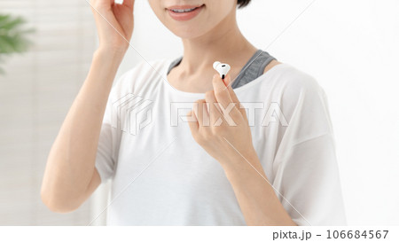 イヤホンで音楽を聴く女性 106684567