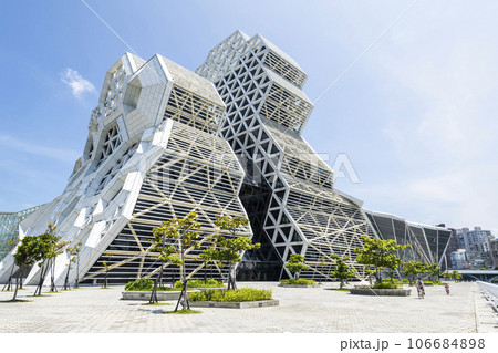 Low angle view of Kaohsiung Music Center in Taiwan. The white hexagonal building structure on the shore of Kaohsiung Port. 106684898