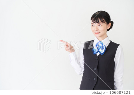 指で指し示すベストにリボンタイの制服を着た、受付業務、事務業務の女性 指で指し示すベストにリボンタイの制服を着た、受付業務、事務業務の女性 106687121