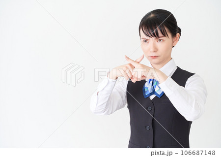 腕でバツ印を作るベストにリボンタイの制服を着た、受付業務、事務業務の女性 腕でバツ印を作るベストにリボンタイの制服を着た、受付業務、事務業務の女性 106687148