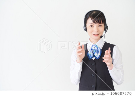ヘッドセットをするベストにリボンタイの制服を着た、受付業務、事務業務の女性 106687570