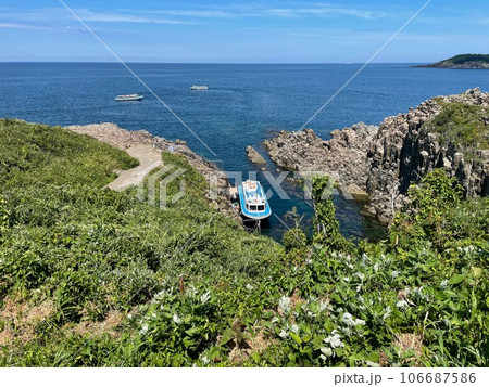断崖絶壁の入り江と岩場の青い海 106687586