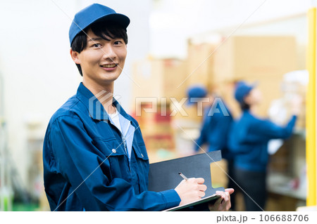 倉庫で働く作業服を着た若い男女の作業員 106688706