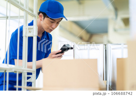 倉庫で荷物を出荷する若い男性の作業員 倉庫で荷物を出荷する若い男性の作業員 106688742