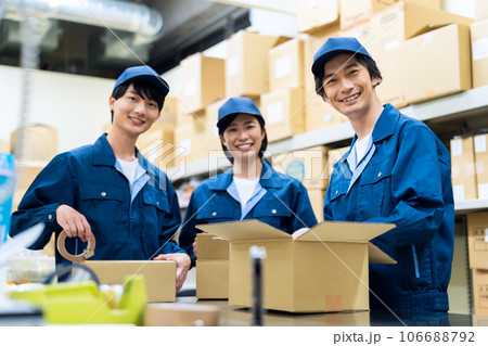 倉庫で荷物を梱包する若い男女の作業員 倉庫で荷物を梱包する若い男女の作業員 106688792