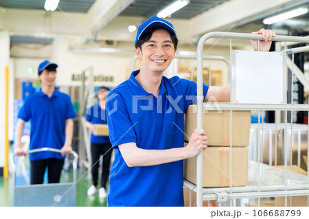 倉庫で荷物を出荷する若い男性の作業員 倉庫で荷物を出荷する若い男性の作業員 106688799