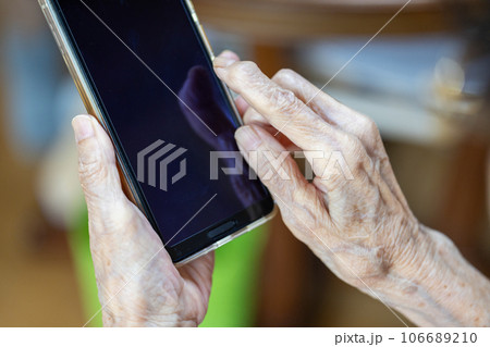 一生懸命スマホを操作している高齢女性の手元 一生懸命スマホを操作している高齢女性の手元 106689210