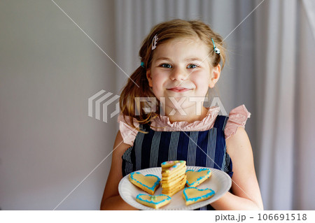 Happy little preschool girl celebrating birthday. Closeup of child with homemade biscuite cake, indoor. Happy healthy kid indoors Happy little preschool girl celebrating birthday. Closeup of child with homemade biscuite cake, indoor. Happy healthy kid indoors 106691518