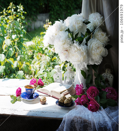Bible and a bouquet of peonies on a table in the garden Bible and a bouquet of peonies on a table in the garden 106691979