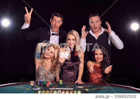 Group of a stylish rich friends are playing poker at casino. 106692032