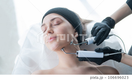 Young caucasian woman on microcurrent therapy procedure. Beautician's office. 106696023