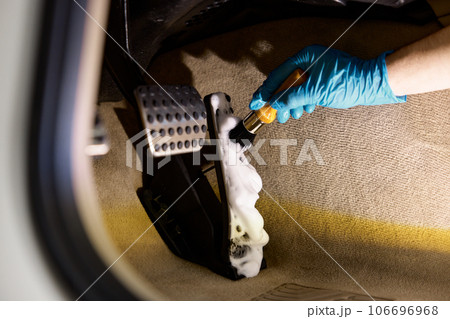 Car detailing procedure, closeup worker hand with brush cleaning pedals 106696968