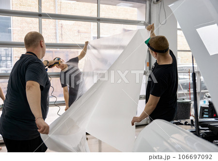 Car service worker team preparing armored protective film for applying Car service worker team preparing armored protective film for applying 106697092