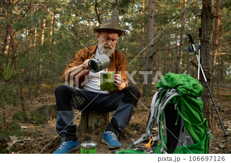 Senior man traveler using portable gas burner to cook dinner 106697126