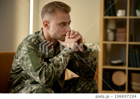 Upset soldier in military uniform thinking worrying about his mental health Upset soldier in military uniform thinking worrying about his mental health 106697284