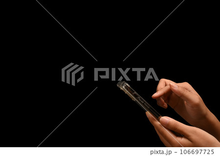 Woman hand holding smartphone isolated on black background with copy space for advertise text Woman hand holding smartphone isolated on black background with copy space for advertise text 106697725