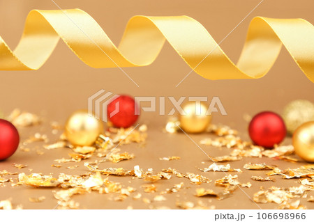 product advertising backdrop. Red gold christmas balls, pieces of gold paper firecracker, gold ribbon on golden background. free place product advertising backdrop. Red gold christmas balls, pieces of gold paper firecracker, gold ribbon on golden background. free place 106698966