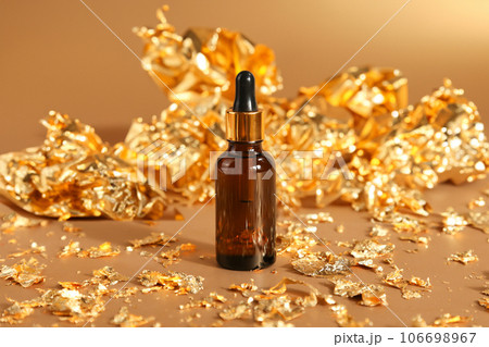 cosmetic serum essential oil bottle with pipette, gold paper on golden background. skincare, moisturizer beauty product, mockup, template. front view cosmetic serum essential oil bottle with pipette, gold paper on golden background. skincare, moisturizer beauty product, mockup, template. front view 106698967