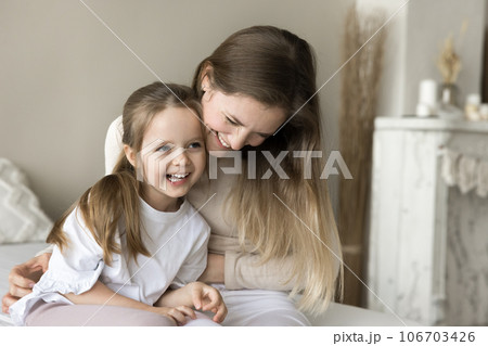 Joyful young mother playing with toddler child on bed 106703426