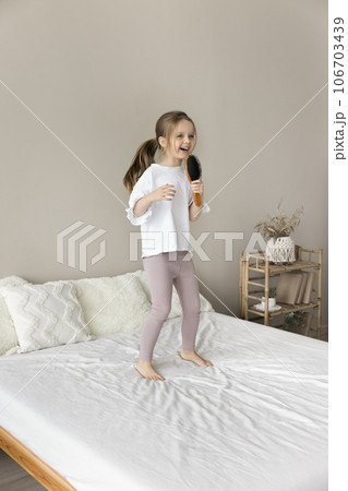 Happy adorable toddler girl singing song at brush microphone Happy adorable toddler girl singing song at brush microphone 106703439