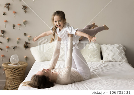 Cheerful excited little girl playing airplane flight, keeping balance 106703531