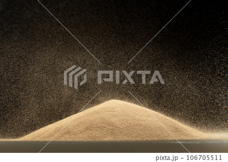 Sand fall down on hill like a rain and splash fly in air. Sand dune hill over wind storm and blast dust splash over mountain. Sunshine rain fall on sand hill wind blow. Black background isolated Sand fall down on hill like a rain and splash fly in air. Sand dune hill over wind storm and blast dust splash over mountain. Sunshine rain fall on sand hill wind blow. Black background isolated 106705511