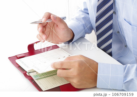 手帳でスケジュール管理する男性 106709159