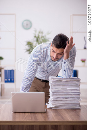 Young male employee and too much work in the office 106710377