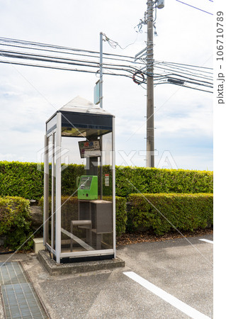 地方都市の駐車場の片隅に設置された公衆電話 106710789