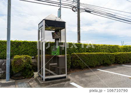 地方都市の駐車場の片隅に設置された公衆電話 地方都市の駐車場の片隅に設置された公衆電話 106710790