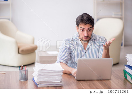 Young male employee and too much work in the office Young male employee and too much work in the office 106711261