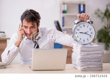 Young male employee in time management concept Young male employee in time management concept 106712428