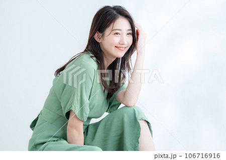 木漏れ日の白バックでスキンケアをする若い女性 106716916