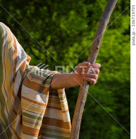 Man's hand with a wooden staff 106719705