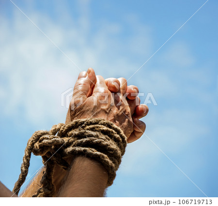 Rope tied hands on sky background 106719713