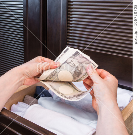 【主婦がたんすの引き出の一万円札を数える】 106720708