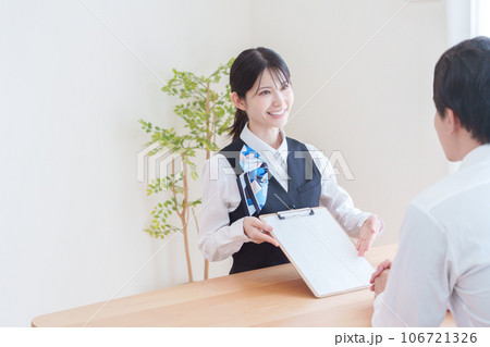 契約書の説明をする受付スタッフ 106721326