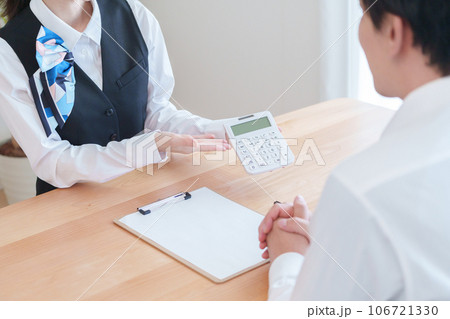 料金の説明をする受付スタッフ 106721330