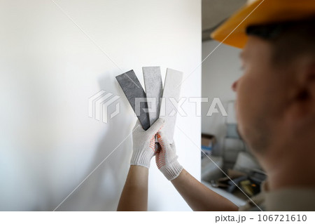 Male builder in white protective gloves hold gray Male builder in white protective gloves hold gray 106721610