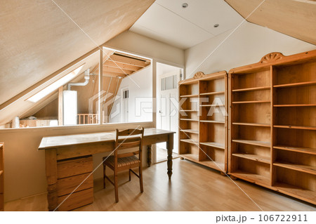 an attic style room with wood floors and built in shelvings on the wall to make it look like a loft an attic style room with wood floors and built in shelvings on the wall to make it look like a loft 106722911