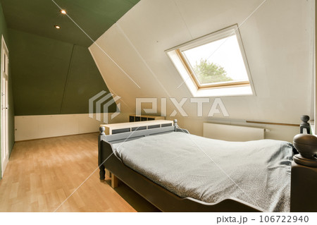 a bed in the corner of a room with green walls and white trim on the ceiling, there is a window a bed in the corner of a room with green walls and white trim on the ceiling, there is a window 106722940